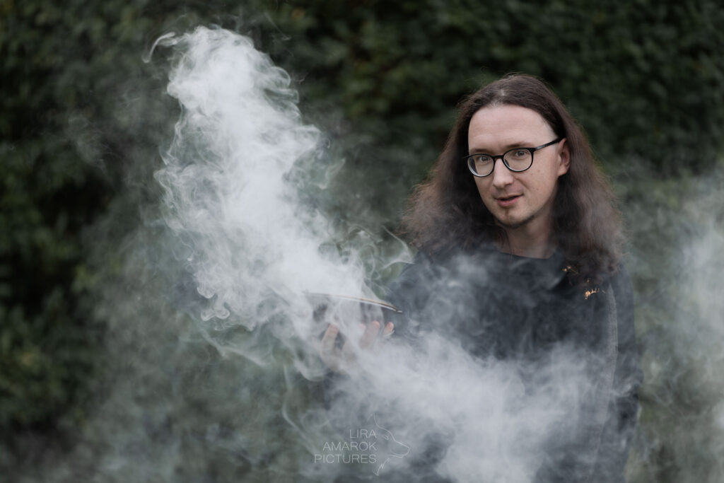 alles Nebel Langhaariger Mann mit Räucherschale in der Hand, aus der viel Rauch raus kommt